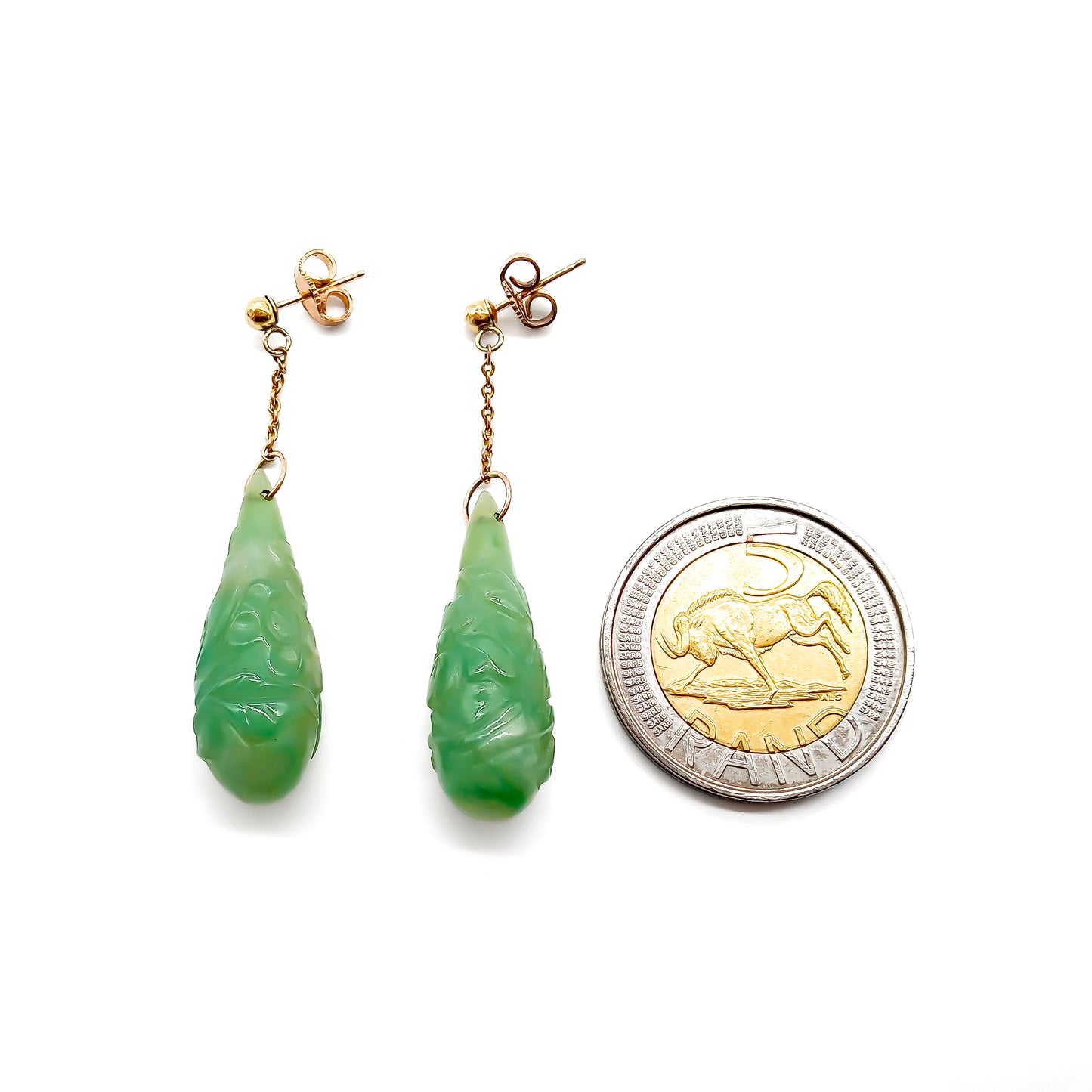 Sought-after 9ct rose gold dangling earrings, each set with a beautifully carved pear-shaped jade drop. Circa 1940’s