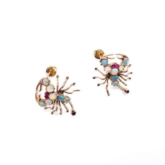 Charming 9ct rose gold earrings, each set with seven cabochon opals, ruby eyes and a ruby tail. Circa 1930’s