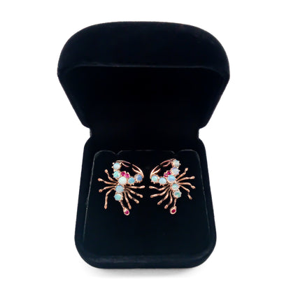 Charming 9ct rose gold earrings, each set with seven cabochon opals, ruby eyes and a ruby tail. Circa 1930’s