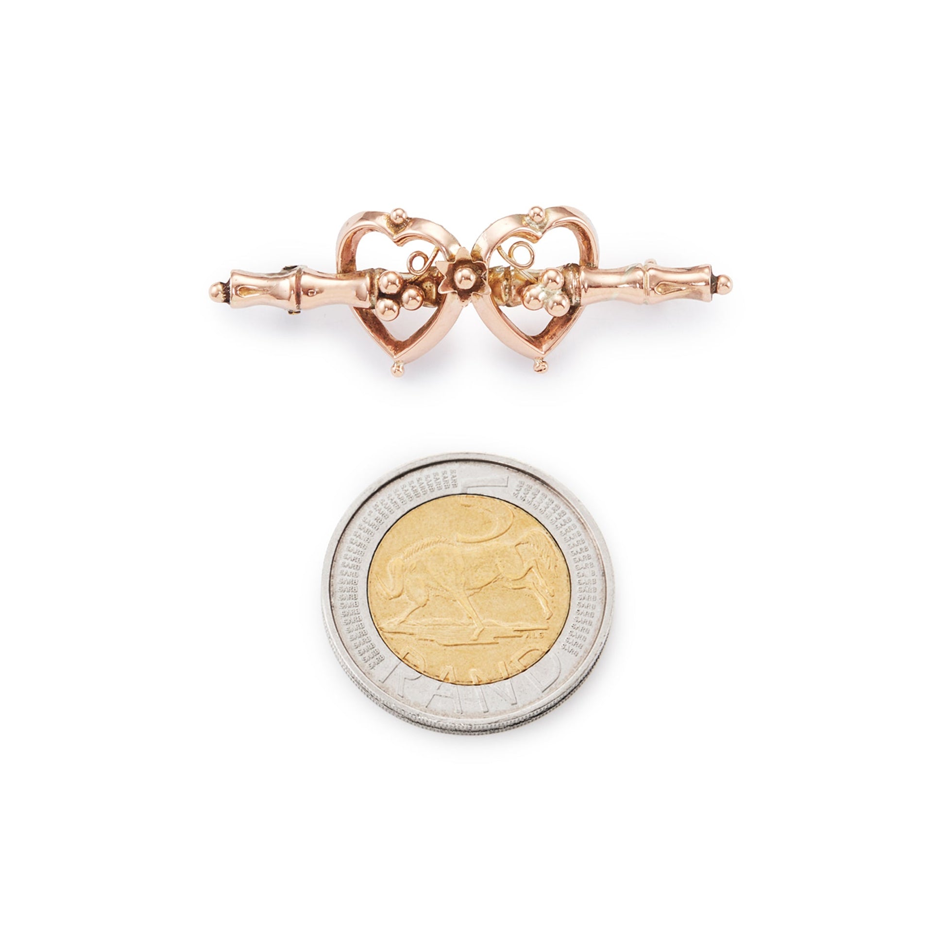 Pretty Victorian 9ct rose gold brooch depicting two hearts with floral details.