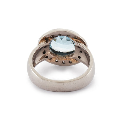 Stunning 9ct white gold ring set with a beautifully faceted blue topaz, surrounded by sixteen small round diamonds.
