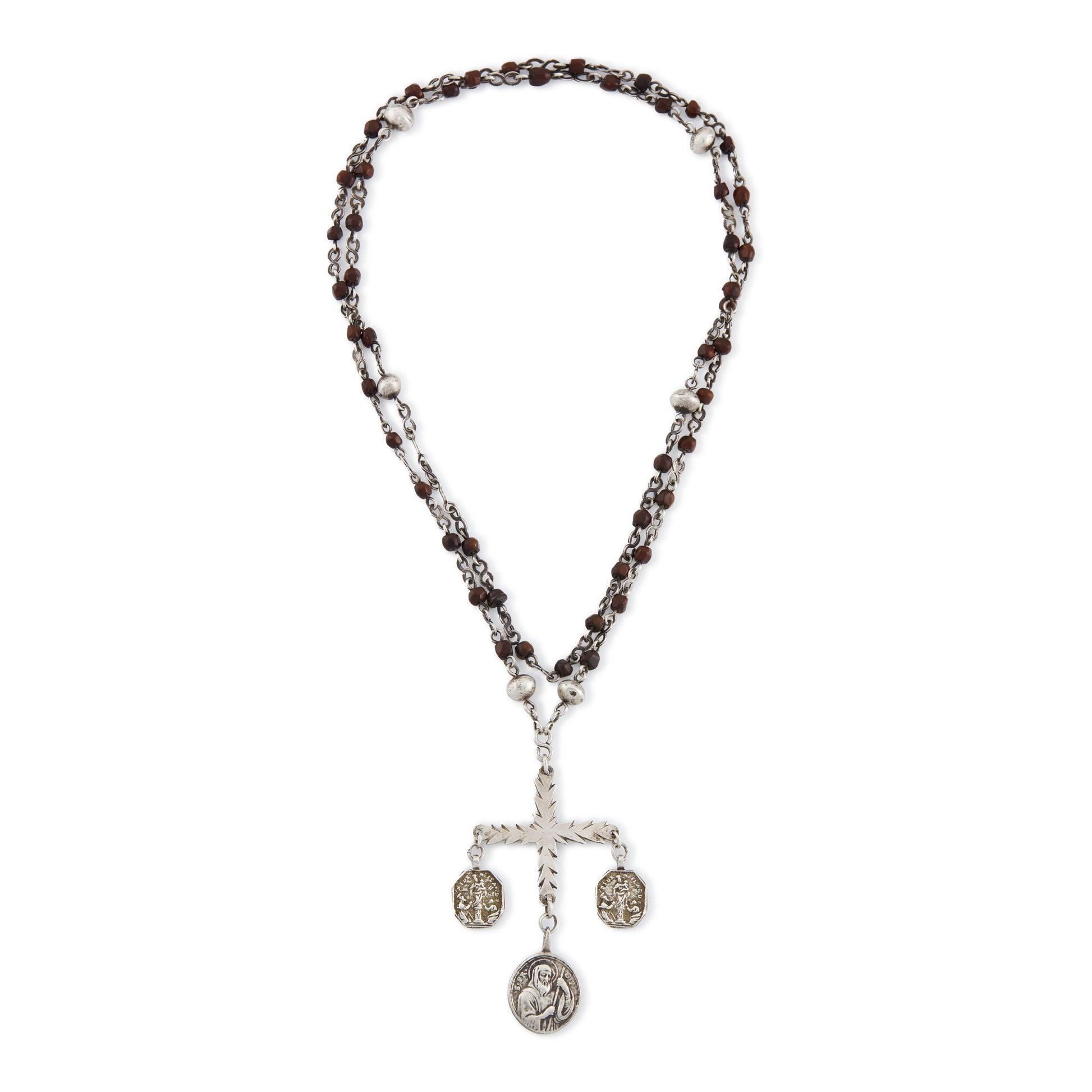 Stunning antique silver rosary with a cross and three dangling saint discs. The cross hangs on a 102cm oxidised silver ornate link chain, interspersed with natural red-brown stones and six silver bobbles.