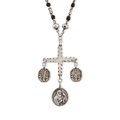 Stunning antique silver rosary with a cross and three dangling saint discs. The cross hangs on a 102cm oxidised silver ornate link chain, interspersed with natural red-brown stones and six silver bobbles.