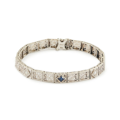 Elegant Art Deco 14ct white gold filigree bracelet set with two round, natural diamonds and a deep-blue sapphire.