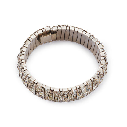 Glamorous articulated Art Deco metal bracelet set with an abundance of paste stones in varying shades of white.