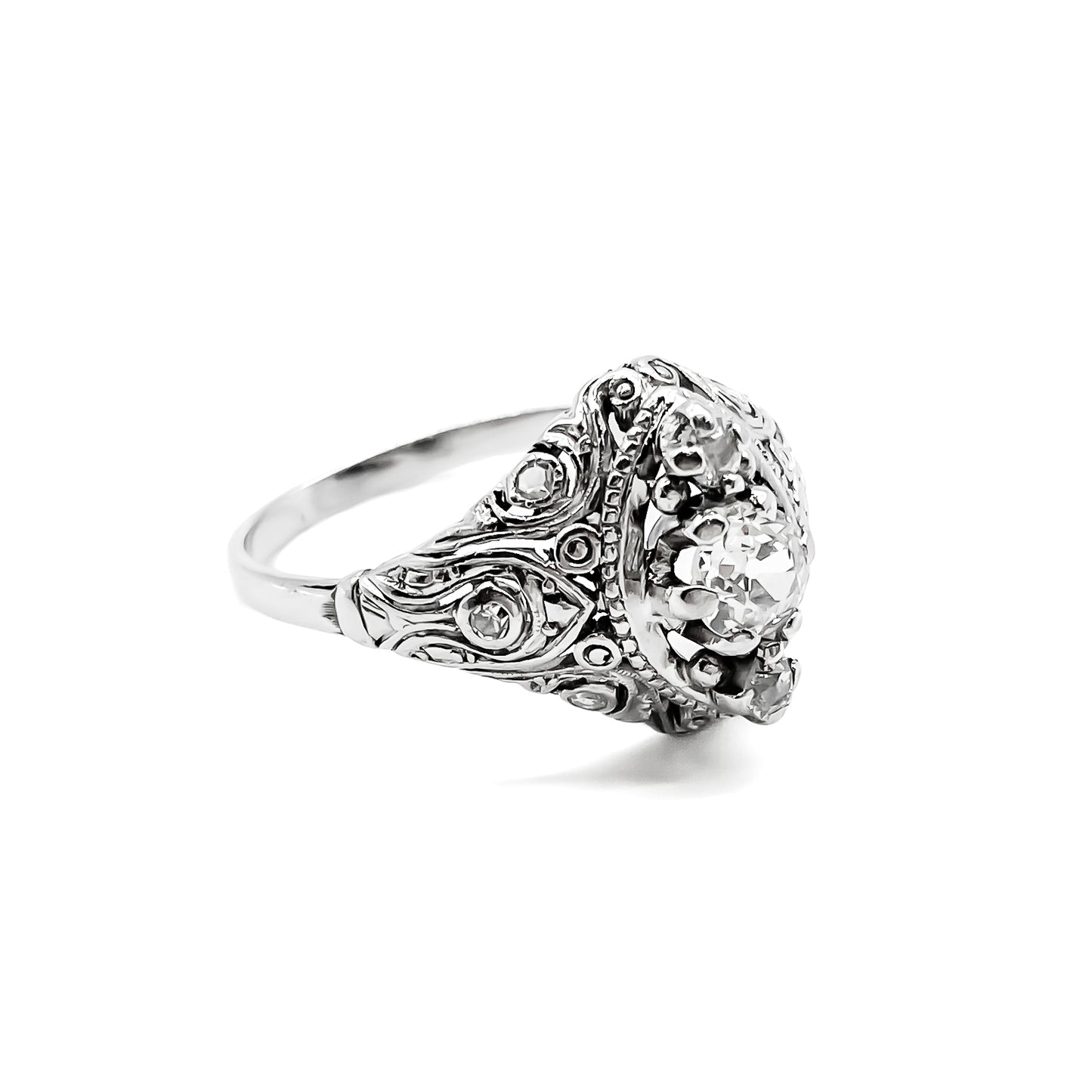 Pretty Art Deco platinum ring set with three centre diamonds and three small diamonds on each shoulder, complemented with beautiful filigree detail.