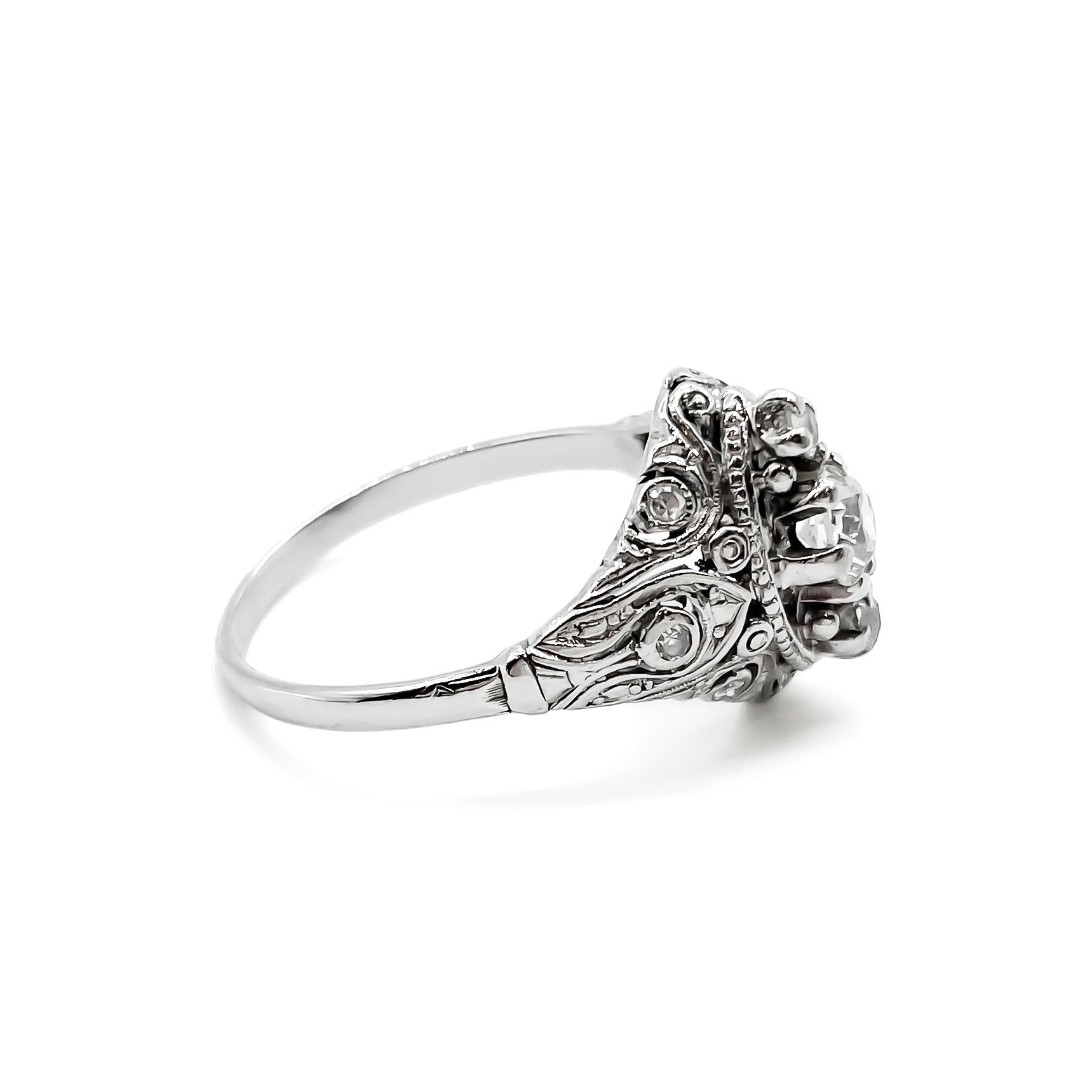 Pretty Art Deco platinum ring set with three centre diamonds and three small diamonds on each shoulder, complemented with beautiful filigree detail.