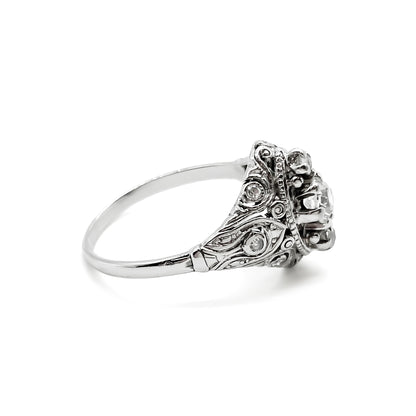 Pretty Art Deco platinum ring set with three centre diamonds and three small diamonds on each shoulder, complemented with beautiful filigree detail.