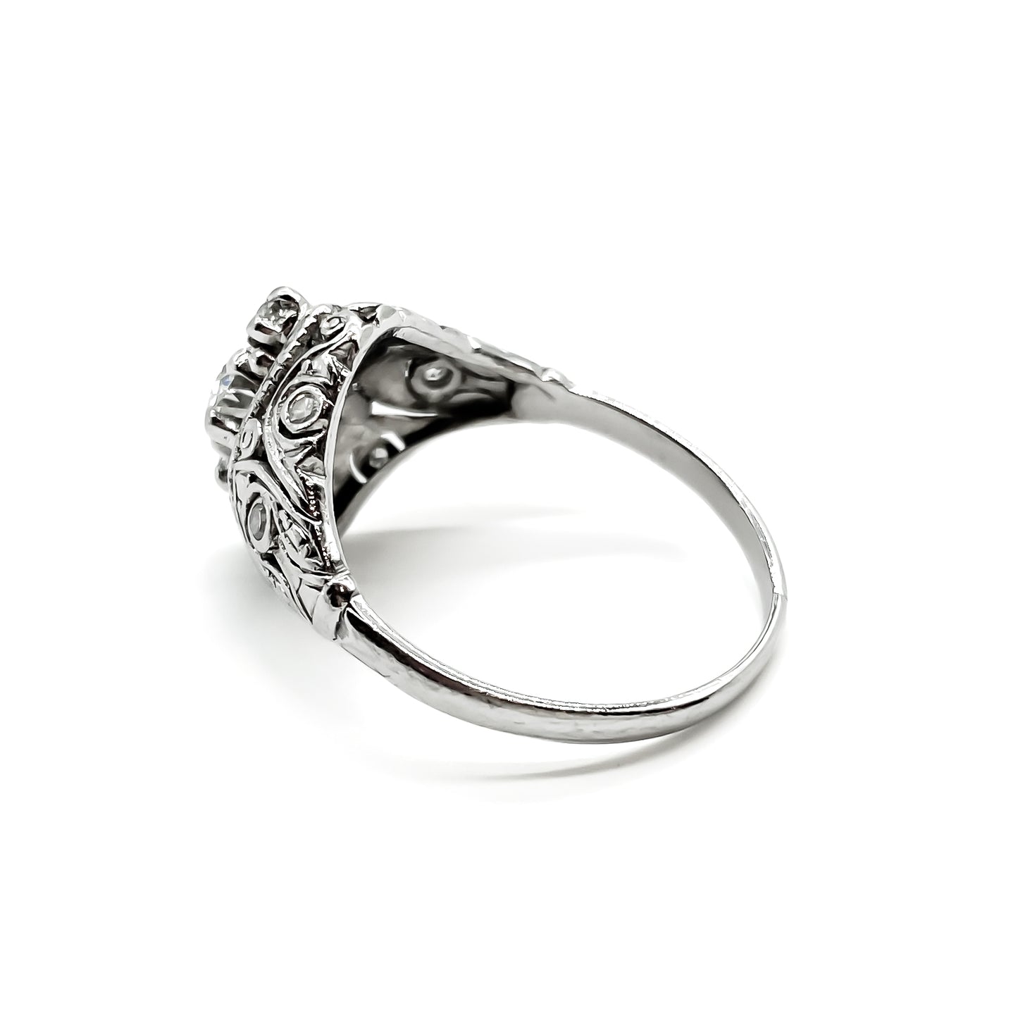 Pretty Art Deco platinum ring set with three centre diamonds and three small diamonds on each shoulder, complemented with beautiful filigree detail.