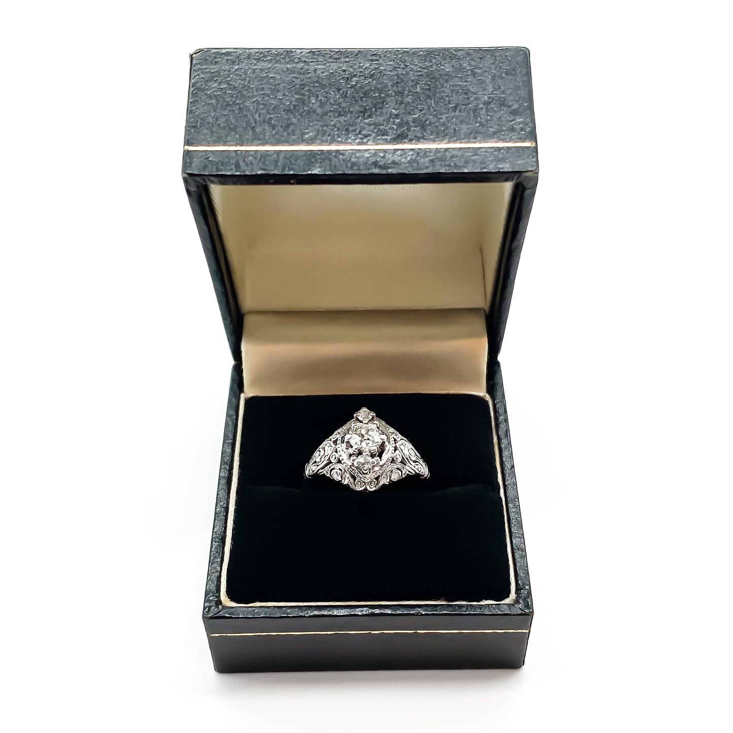 Pretty Art Deco platinum ring set with three centre diamonds and three small diamonds on each shoulder, complemented with beautiful filigree detail.