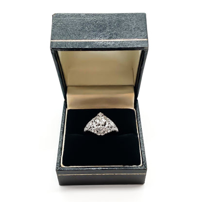 Pretty Art Deco platinum ring set with three centre diamonds and three small diamonds on each shoulder, complemented with beautiful filigree detail.