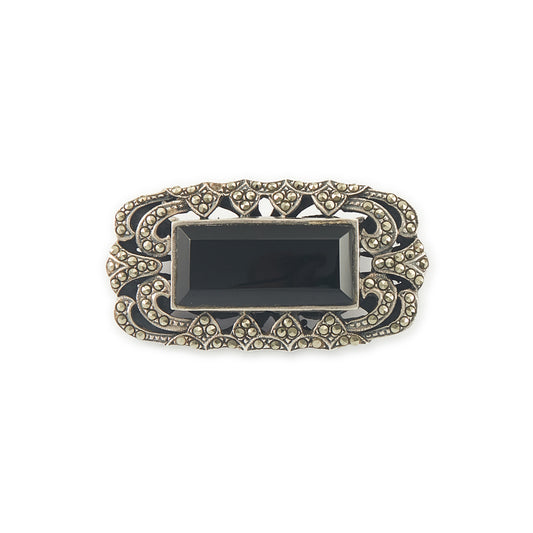 Stylish Art Deco sterling silver marcasite brooch set with a rectangular black onyx stone. Safety clasp.