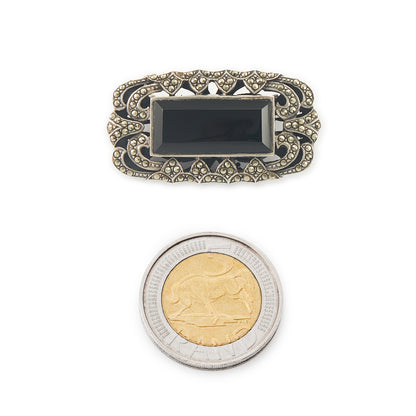 Stylish Art Deco sterling silver marcasite brooch set with a rectangular black onyx stone. Safety clasp.