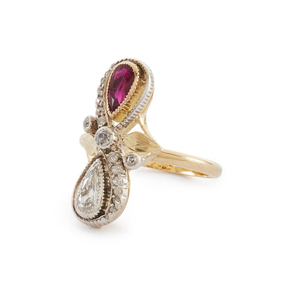 Magnificent Art Nouveau ring set with a pear-shaped ruby and an old-cut, pear-shaped diamond, surrounded by sixteen smaller old-cuts. A finely crafted leaf sits on either side of the centre diamond.