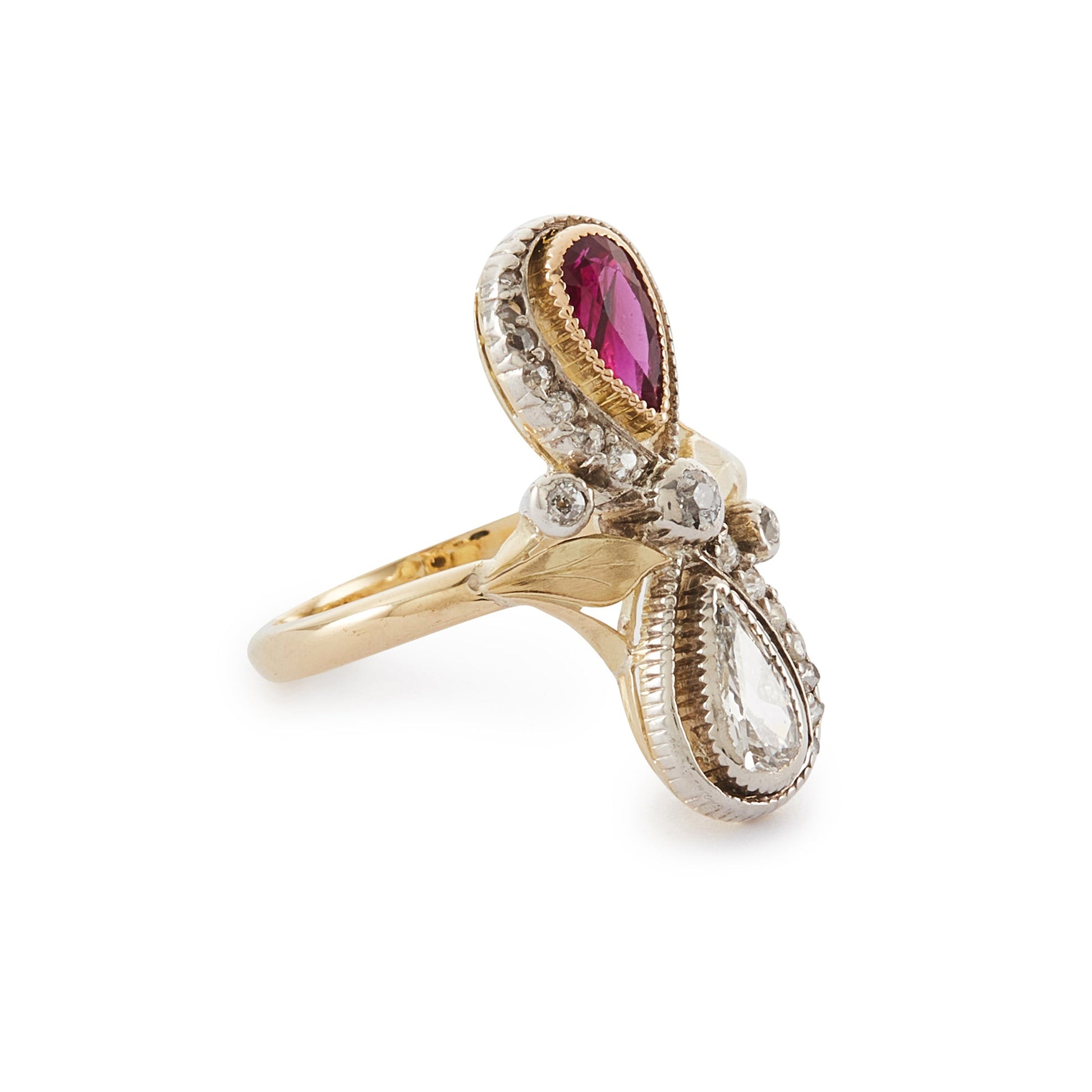 Magnificent Art Nouveau ring set with a pear-shaped ruby and an old-cut, pear-shaped diamond, surrounded by sixteen smaller old-cuts. A finely crafted leaf sits on either side of the centre diamond.