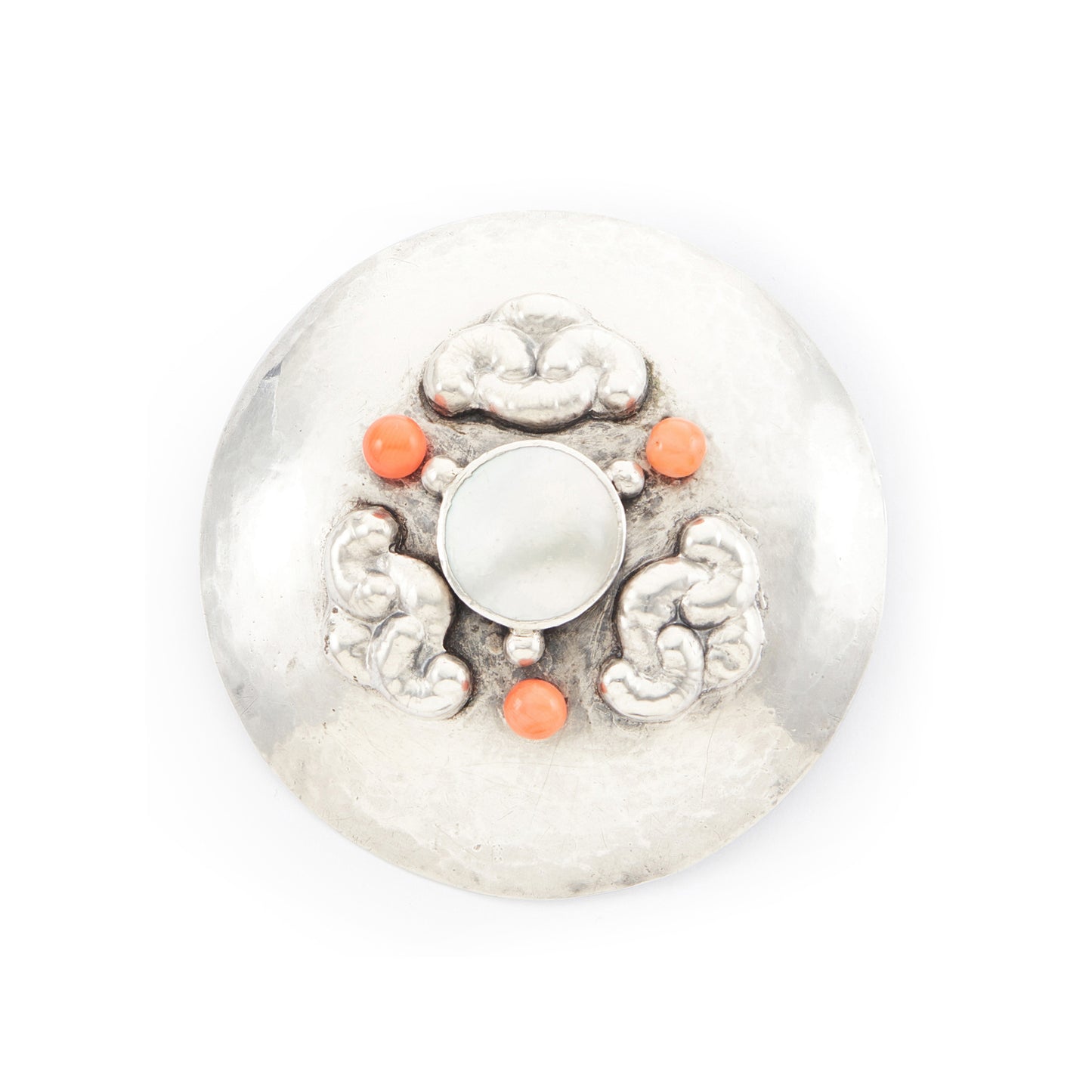 Large hand-beaten silver Arts and Crafts brooch set with a Mother of Pearl disc in the centre, surrounded by three coral beads and a repoussé design.
