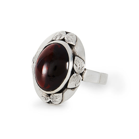 Lovely silver Arts and Crafts ring, set with a deep red oval cabochon garnet in an engraved leaf setting.