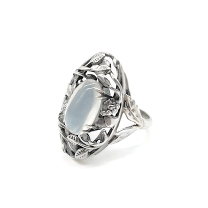 Gorgeous Arts and Crafts silver ring set with an oval cabochon moonstone in an ornate leaf setting.