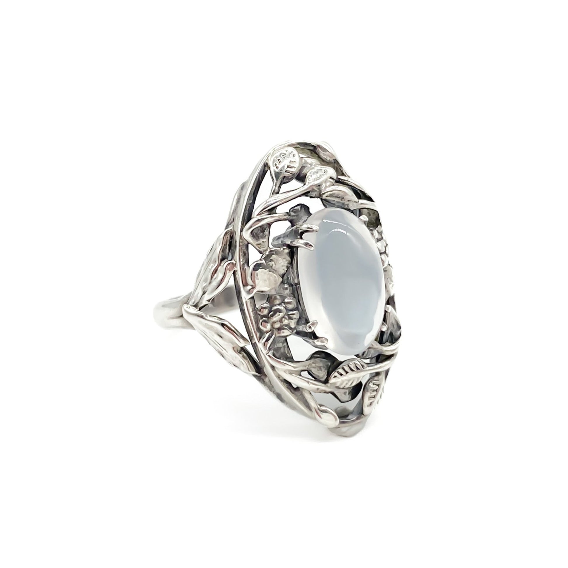 Gorgeous Arts and Crafts silver ring set with an oval cabochon moonstone in an ornate leaf setting.