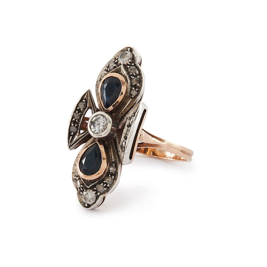 Gorgeous Edwardian 18ct rose gold and silver ring set with three round old-European-cut diamonds, two teardrop sapphires and eighteen smaller mine-cut diamond chips. The centre old-cut diamond has a natural inclusion that adds character to the piece.