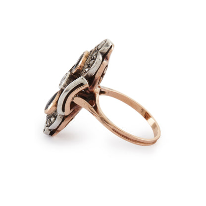 Gorgeous Edwardian 18ct rose gold and silver ring set with three round old-European-cut diamonds, two teardrop sapphires and eighteen smaller mine-cut diamond chips. The centre old-cut diamond has a natural inclusion that adds character to the piece.