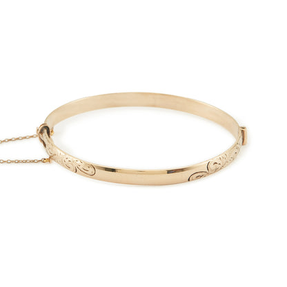 Beautifully engraved Edwardian 9ct gold bronze-core hinge bangle with a safety chain.