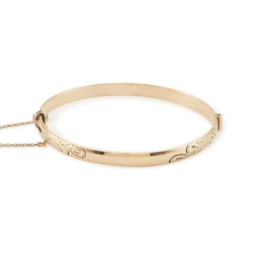 Beautifully engraved Edwardian 9ct gold bronze-core hinge bangle with a safety chain.