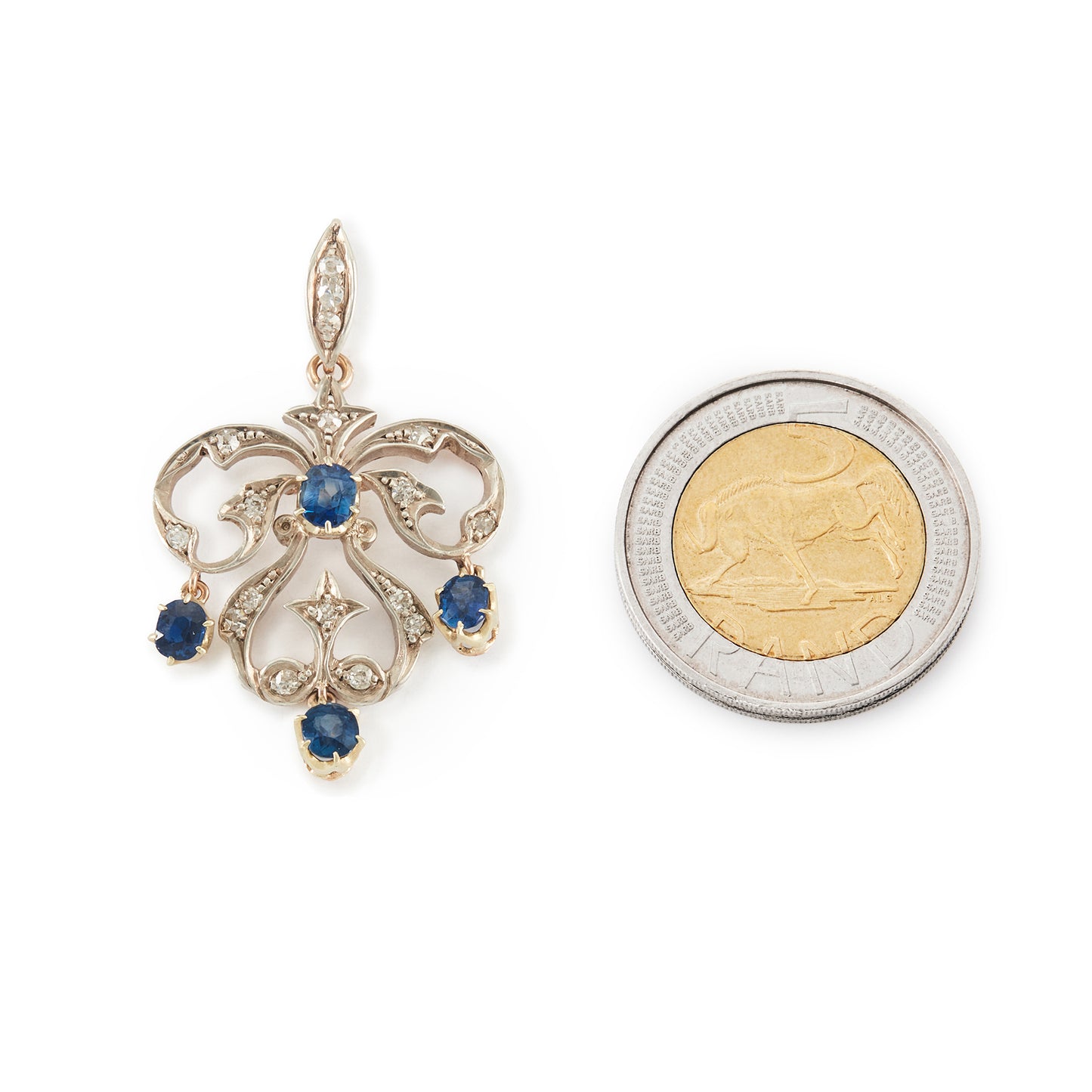 Exquisite Edwardian 9ct gold and silver pendant set with four bright blue sapphires and seventeen small old-cut diamonds.