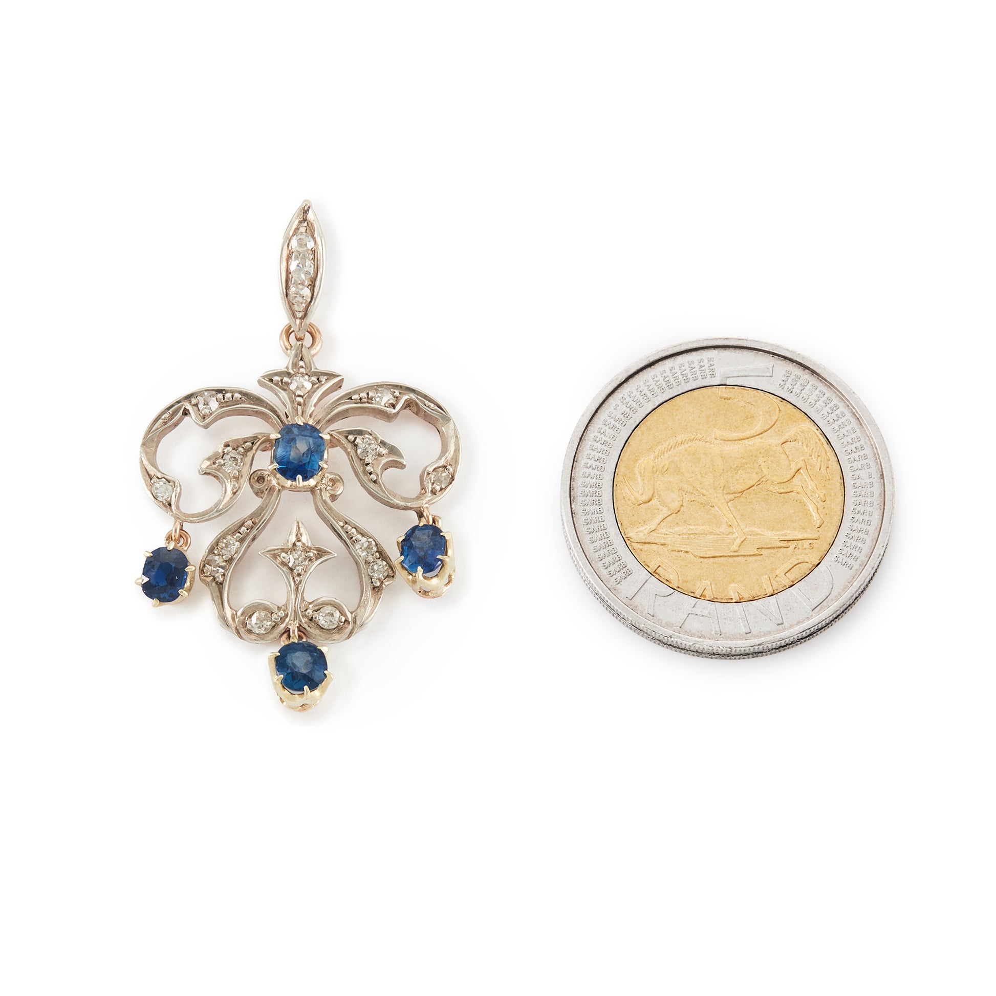 Exquisite Edwardian 9ct gold and silver pendant set with four bright blue sapphires and seventeen small old-cut diamonds.