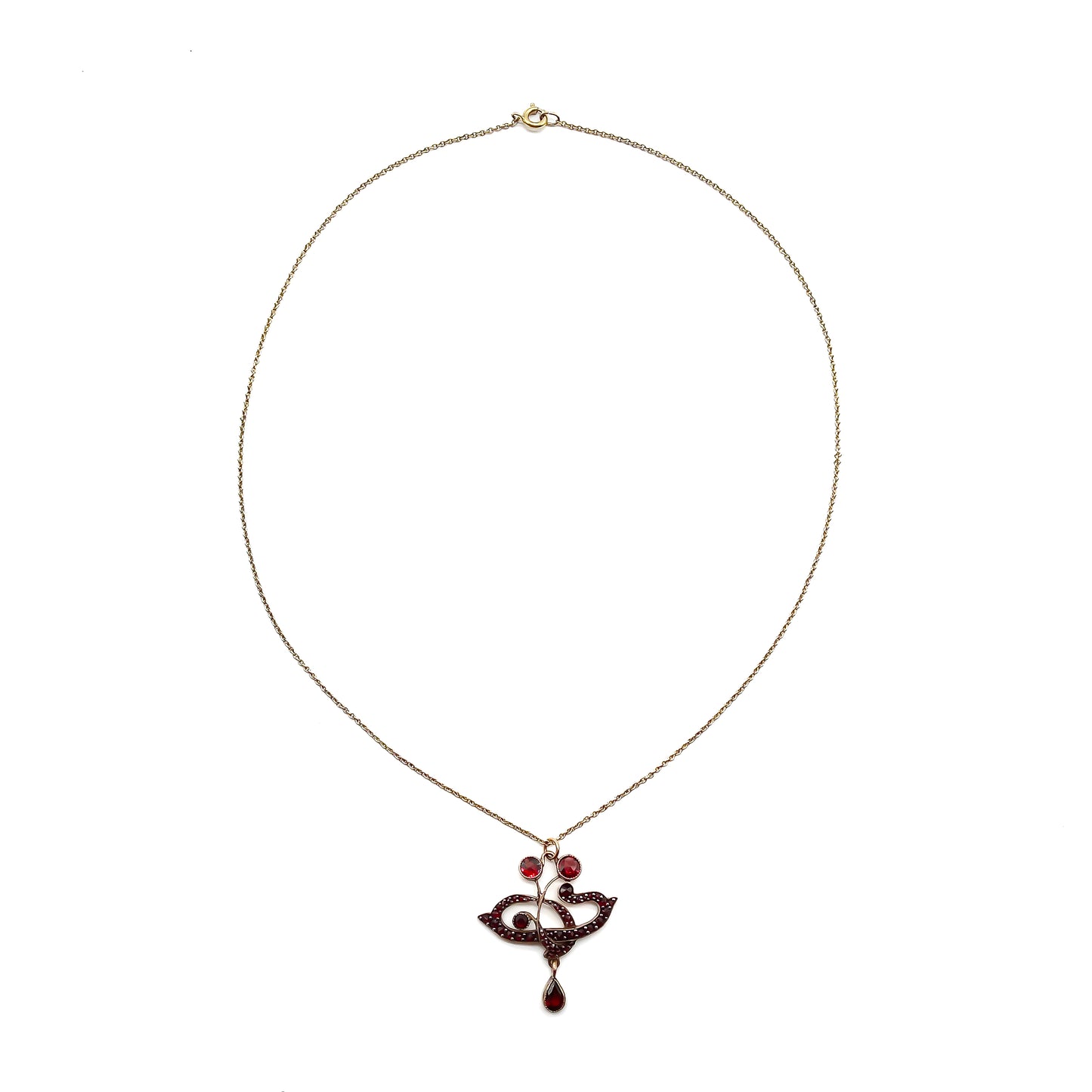 Delicate Edwardian pendant set with deep red Bohemian garnets on a silver gilt chain.