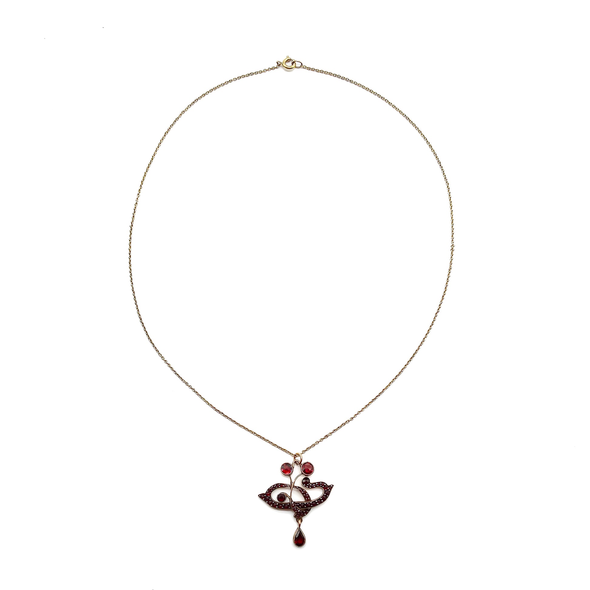 Delicate Edwardian pendant set with deep red Bohemian garnets on a silver gilt chain.