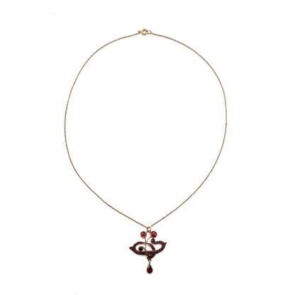 Delicate Edwardian pendant set with deep red Bohemian garnets on a silver gilt chain.