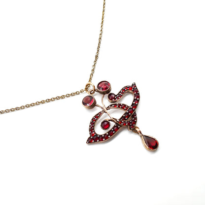 Delicate Edwardian pendant set with deep red Bohemian garnets on a silver gilt chain.