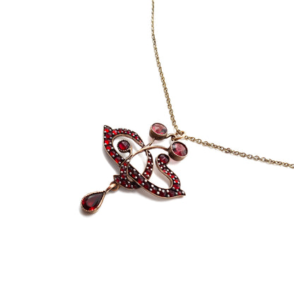 Delicate Edwardian pendant set with deep red Bohemian garnets on a silver gilt chain.