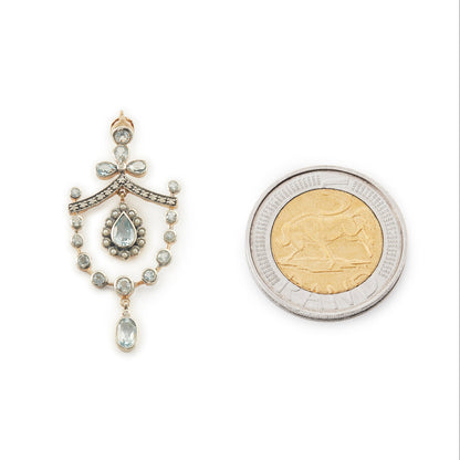 Pretty Edwardian-style gold on silver pendant set with seventeen light blue topaz stones, fifteen small diamonds and twelve tiny seed pearls.
