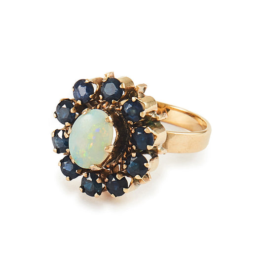 Gorgeous Mid-Century 14ct gold ring set with an oval cabochon opal in the centre, surrounded by ten deep blue sapphires. 