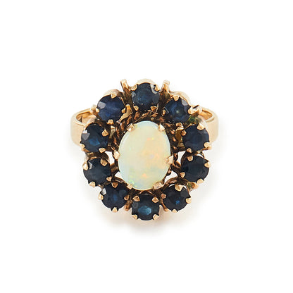 Gorgeous Mid-Century 14ct gold ring set with an oval cabochon opal in the centre, surrounded by ten deep blue sapphires. 