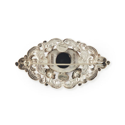 Ornate Mid-Century sterling silver Candida brooch set with an onyx cabochon stone, surrounded with a repoussé design. South Africa