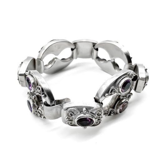 Ornate silver bracelet set with twelve oval faceted amethysts (800 silver). Circa 1930’s