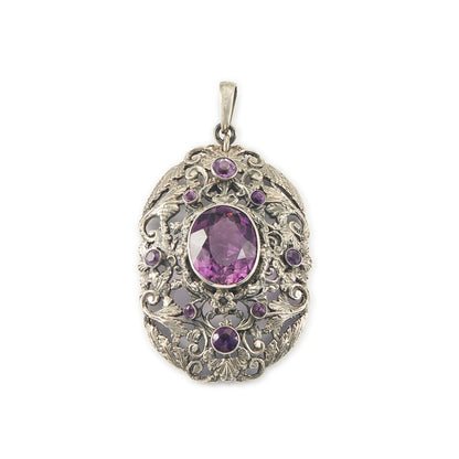 Regal silver pendant set with a large, beautifully faceted purple amethyst stone, surrounded by  eight small amethysts in an intricate design.