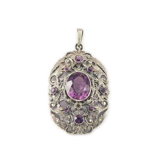Regal silver pendant set with a large, beautifully faceted purple amethyst stone, surrounded by  eight small amethysts in an intricate design.