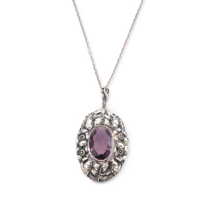 Very ornate oval pendant with a beautifully faceted purple amethyst in a floral setting, on a silver chain. 800 Silver. German