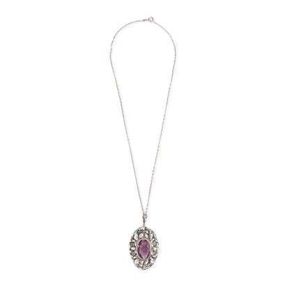 Very ornate oval pendant with a beautifully faceted purple amethyst in a floral setting, on a silver chain. 800 Silver. German