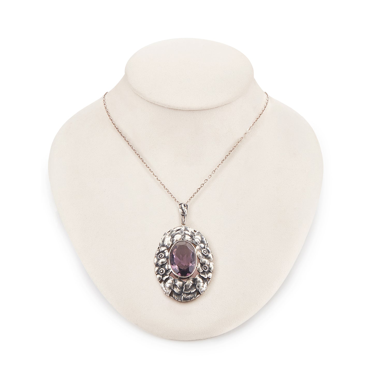 Very ornate oval pendant with a beautifully faceted purple amethyst in a floral setting, on a silver chain. 800 Silver. German