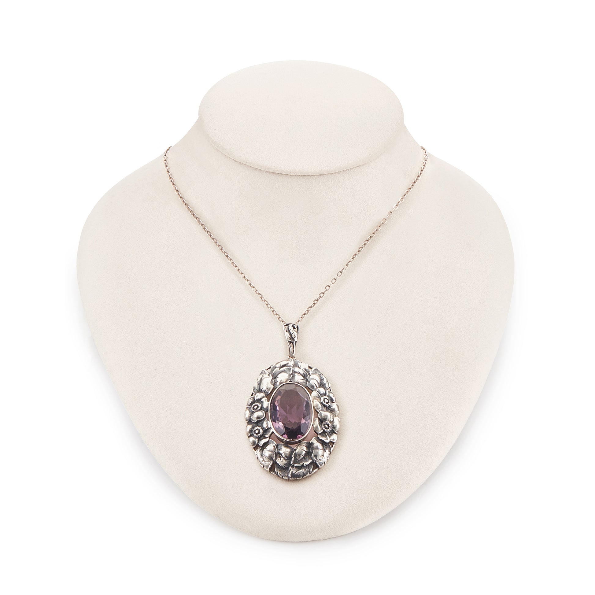 Very ornate oval pendant with a beautifully faceted purple amethyst in a floral setting, on a silver chain. 800 Silver. German