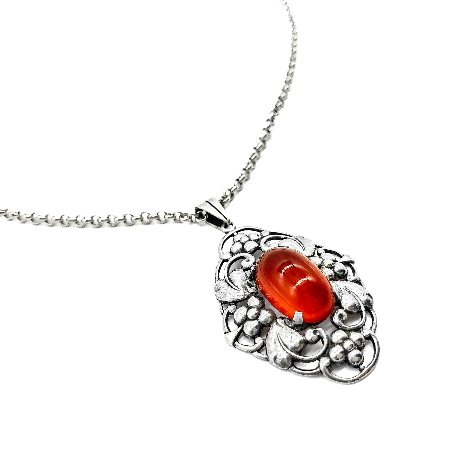 Lovely silver Arts and Crafts pendant set with an oval cabochon carnelian, on a vintage silver chain. Circa 1910