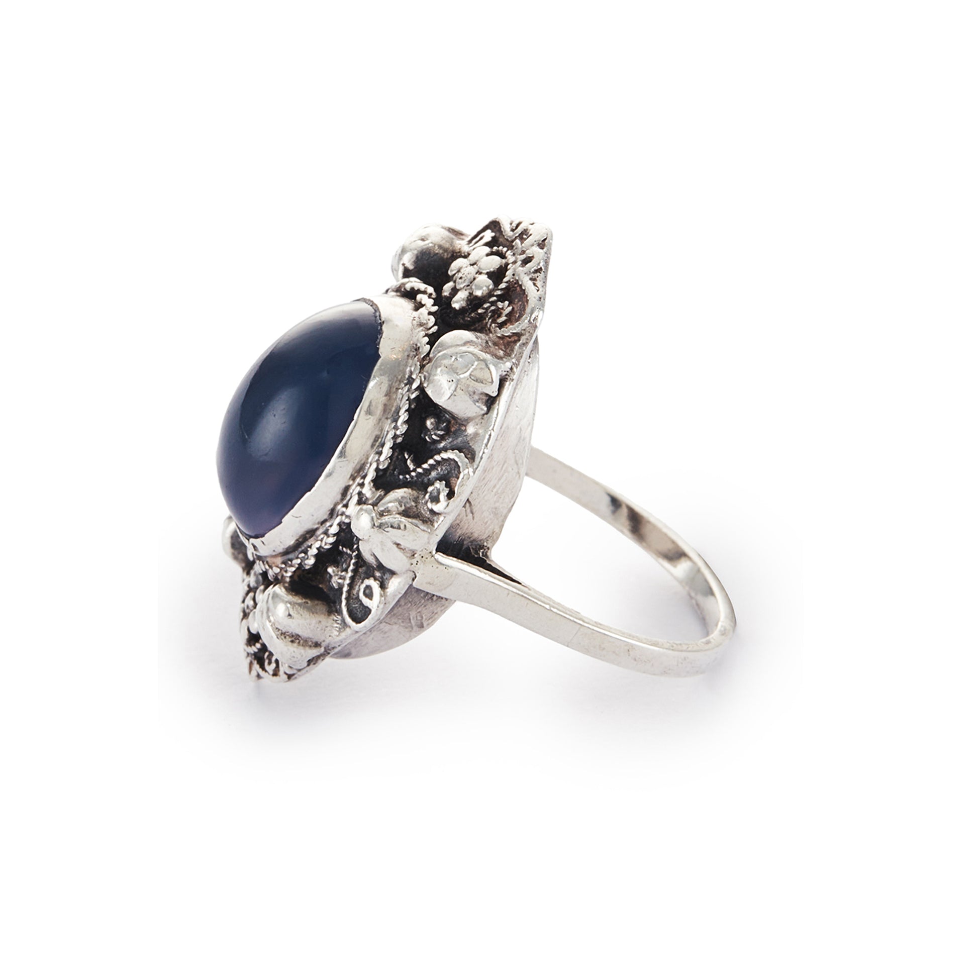 Lovely silver Arts and Crafts ring set with a cabochon sodalite, surrounded by intricate floral detail.