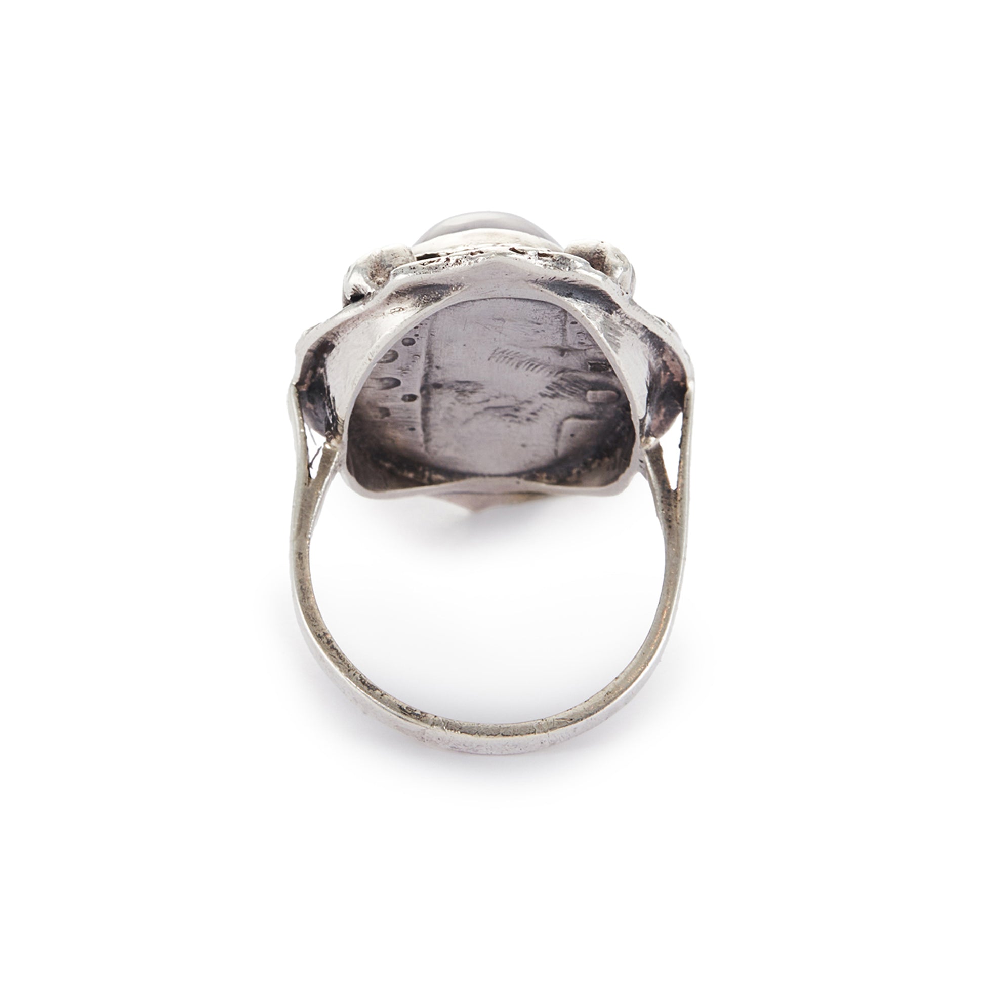 Lovely silver Arts and Crafts ring set with a cabochon sodalite, surrounded by intricate floral detail.