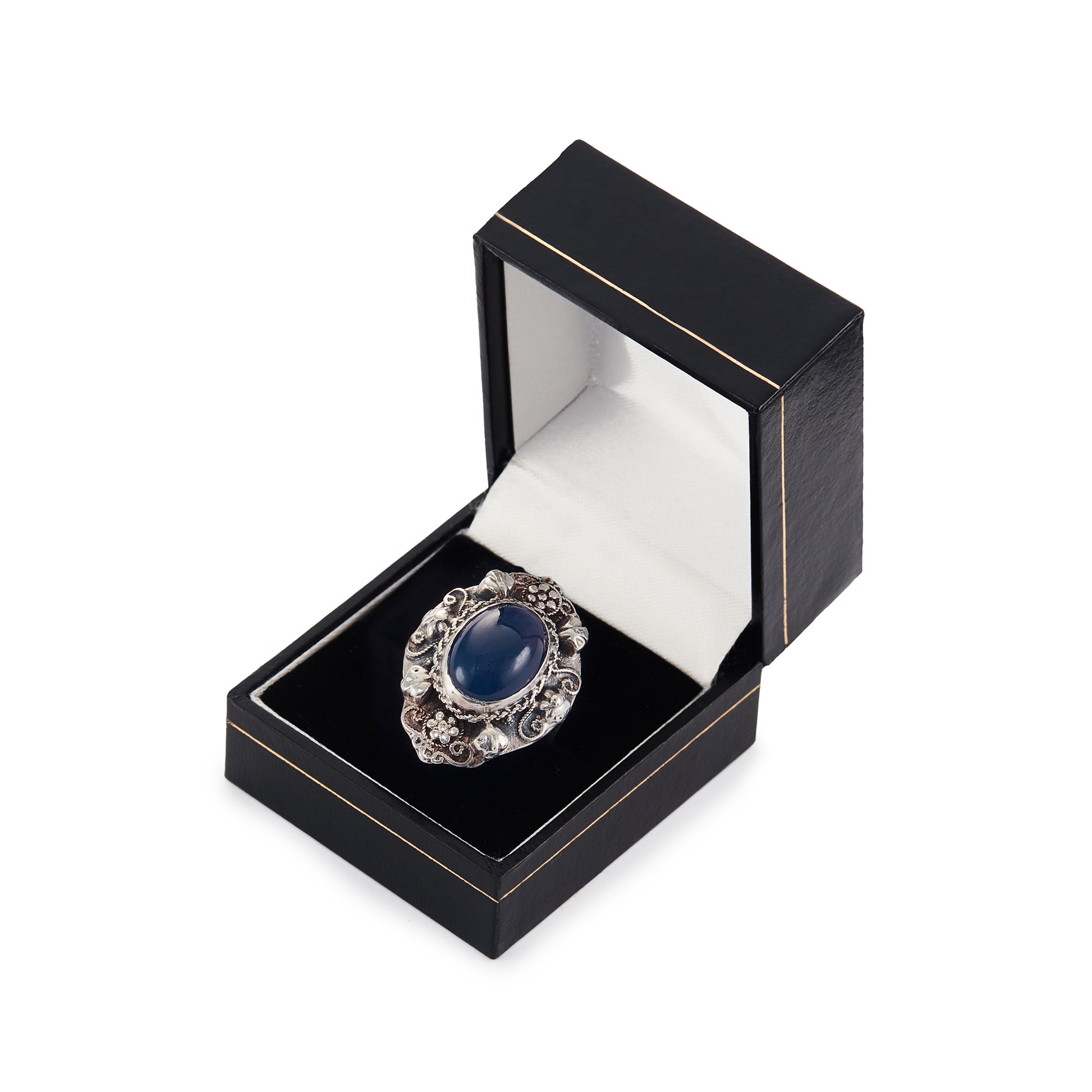 Lovely silver Arts and Crafts ring set with a cabochon sodalite, surrounded by intricate floral detail.