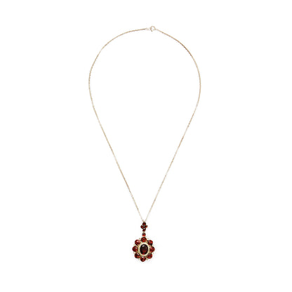 Exquisite silver gilt pendant on a silver chain, set with thirteen deep red old cut garnets and a larger oval garnet surrounded by marcasites in the centre.